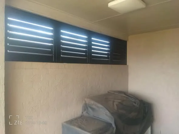 Charcoal aluminium plantation shutters letting through soft light